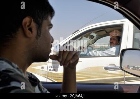 Indische und Oman Jungs sprechen einander aus dem Auto : Maskat, Oman - 15-09-2020 Stockfoto