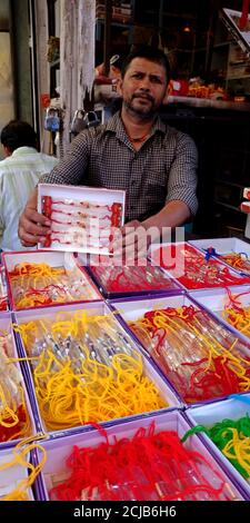 DISTRIKT KATNI, INDIEN - 12. AUGUST 2019: Ein asiatischer traditioneller Ladenbesitzer, der während des traditionellen hinduistischen Festivals auf asiatischer Bude schöne Rakhi verkauft Stockfoto