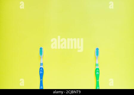 Zwei Zahnbürsten auf gelbem Hintergrund. Draufsicht, minimales flaches Lay. Stockfoto