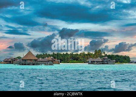 Wasserbungalows vor einer Insel auf den Malediven Stockfoto