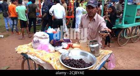 DISTRIKT KATNI, INDIEN - 15. AUGUST 2019: Asiatischer Ladenbesitzer, der während des Unabhängigkeitstages auf der Straße süßen trockenen Beri Labdo anbietet. Stockfoto