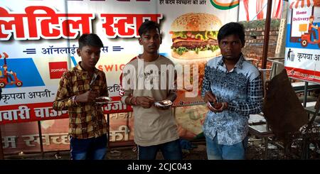 DISTRIKT KATNI, INDIEN - 15. AUGUST 2019: Indische Jungen essen Pani puri im Straßenladen während der Unabhängigkeit Tag Markt auf der Straße. Stockfoto