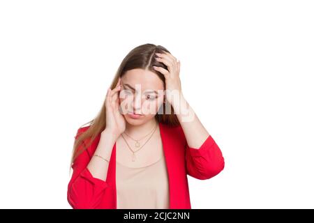 Eine junge Geschäftsfrau in einem roten Anzug, hält seine Hände hinter dem Kopf, erlebt Stress, ein Hintergrund in weiß isoliert Stockfoto
