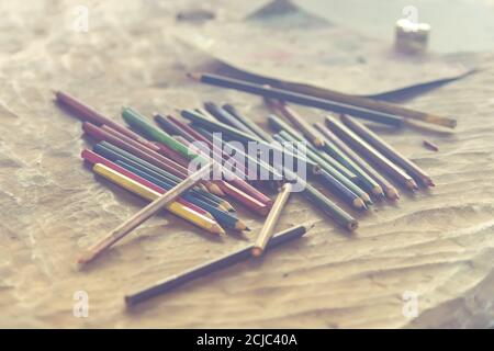 Arbeitsplatz des Künstlers. Stapel von bunten Bleistiften auf Steintisch. Retro-Farben. Stockfoto