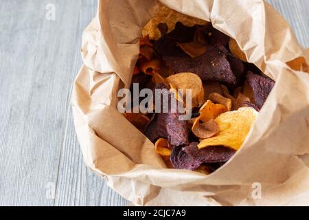 Gemüsechips in einem Papierbeutel. Geschmack von Süßkartoffeln, Rote Beete und Pastinak. Veganes Lebensmittelkonzept Stockfoto