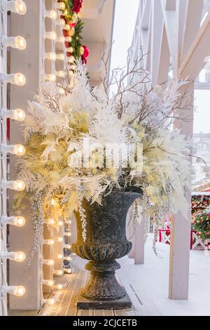 Floristische Komposition im Winter in großer schwarzer Marmorvase. Außendekoration. Stockfoto