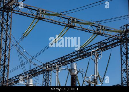 Elektrische Unterstation. Elektrische Träger, Drähte und Isolatoren (Isolatoren) am blauen Himmel. Nahaufnahme. Stockfoto
