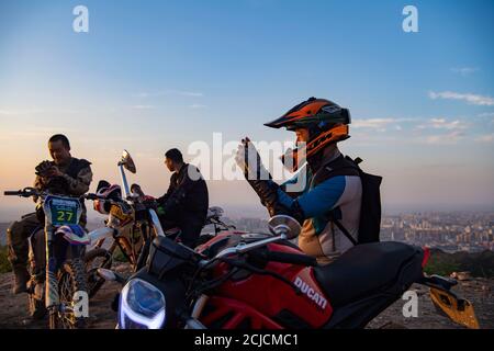 Urumqi. September 2020. Das am 10. September 2020 aufgenommene Foto zeigt den Motorradfahrer Gao Dongxu (R), der mit seinem Telefon in den Bergen nahe Urumqi, der nordwestlichen chinesischen Autonomen Region Xinjiang Uygur, fotografiert. Gao Dongxu, 39 Jahre alt, und seine Freunde sind Langlaufbegeisterte, die gerne neue Reitwege in den Bergen erkunden. Quelle: Hu Huhu/Xinhua/Alamy Live News Stockfoto