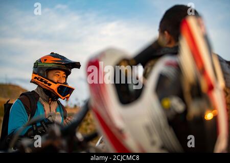 Urumqi. September 2020. Das am 10. September 2020 aufgenommene Foto zeigt den Motorradfahrer Gao Dongxu (L) im Gespräch mit seinem Freund in den Bergen in der Nähe von Urumqi, der nordwestlichen chinesischen Autonomen Region Xinjiang Uygur. Gao Dongxu, 39 Jahre alt, und seine Freunde sind Langlaufbegeisterte, die gerne neue Reitwege in den Bergen erkunden. Quelle: Hu Huhu/Xinhua/Alamy Live News Stockfoto