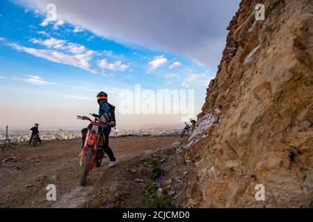 Urumqi. September 2020. Das am 10. September 2020 aufgenommene Foto zeigt den Motorradfahrer Gao Dongxu (vorne), der auf seiner Fahrt in den Bergen in der Nähe von Urumqi, der Autonomen Region Xinjiang Uygur im Nordwesten Chinas, seine Freunde überprüft. Gao Dongxu, 39 Jahre alt, und seine Freunde sind Langlaufbegeisterte, die gerne neue Reitwege in den Bergen erkunden. Quelle: Hu Huhu/Xinhua/Alamy Live News Stockfoto