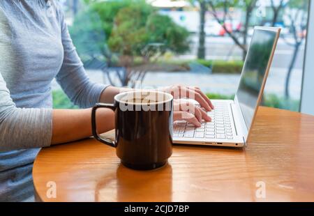 Mit Laptop-Computer und Kaffee in einem Café genießen Stockfoto