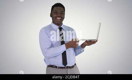 Im Gespräch mit Kamera jungen afrikanischen Mann mit Laptop in seinem Praktische Übungen Stockfoto