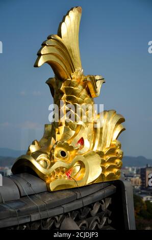 Eine goldene Fischskulptur (Shachihoko) auf dem Dach der Burg Okayama, Japan Stockfoto