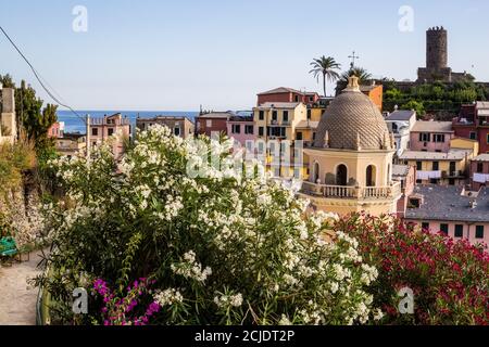 Vernazza, Italien - 8. Juli 2017: Blick auf die Kirche Santa Margherita di Antiochia und bunte Häuser mit Doria Schloss und Ligurisches Meer im Hintergrund Stockfoto