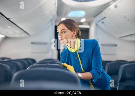 Schöne Stewardess, die in der leeren großen Tafel von Modern arbeitet Internationale Fluggesellschaften Stockfoto