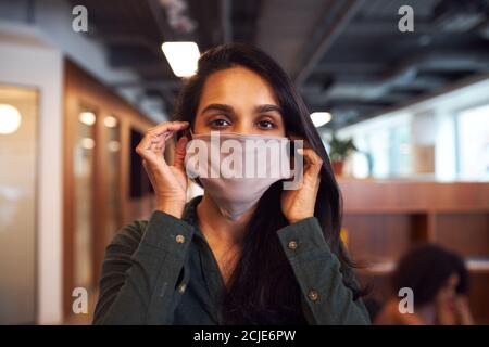 Porträt Der Geschäftsfrau Trägt Gesichtsmaske In Modernen Offenen Plan Büro Während Der Covid-19 Pandemie Stockfoto