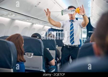 Steward demonstriert Sicherheitsverfahren vor kommerziellen Flug Fluggesellschaft nahm Aus Stockfoto