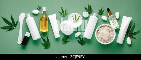 Set von Hanf Hautpflege Kosmetik in weißen Mockup Verpackung. Feuchtigkeitsspendende Creme, Serum, Lotion, CBD-Öl, ätherisches Öl Cannabisblätter. Flach liegend lang Stockfoto