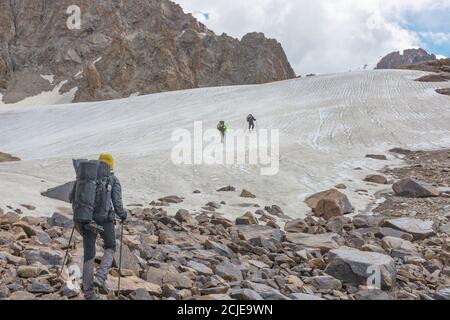 Gruppe von Touristen mit Rucksäcken heben Bergweg zum Gletscher im Nationalpark. Stockfoto