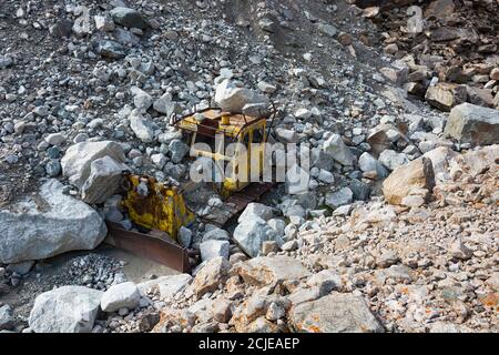 Alte zerstörte gelbe Traktor in den Bergen. Stockfoto