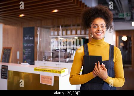 Porträt Der Geschäftsbesitzerin Des Coffee Shop In Maske Verwendung Des Digitalen Tablets Während Der Pandemie Im Gesundheitswesen Stockfoto