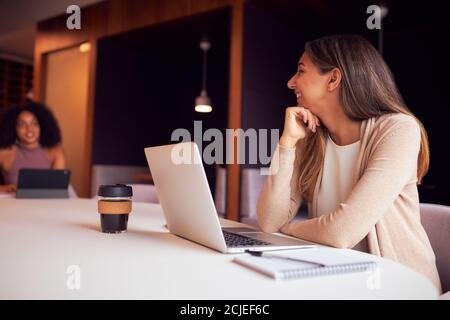 Geschäftsfrau Mit Laptop Bei Gesellschaftlich Distanzierten Treffen Im Büro Während Gesundheitliche Pandemie Stockfoto