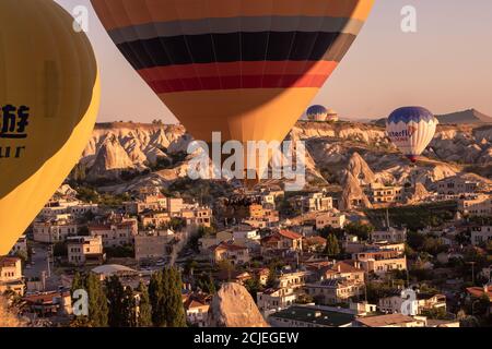 Kappadokien / Türkei - 14. September 2020: Fliegende Heißluftballons und Felslandschaft bei Sonnenaufgang in Goreme, Kappadokien, Türkei Stockfoto