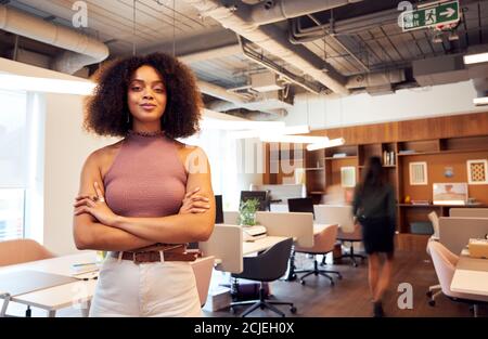 Porträt Einer Lächelnden Geschäftsfrau, Die Im Geschäftigen Modernen Offenen Plan Steht Büro Stockfoto