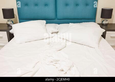 Schlafzimmer mit ungefertigten Doppelbett. Drinnen niemand. Horizontal Stockfoto