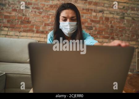 Langhaarige Frau, die auf den Laptop-Bildschirm starrt Stockfoto