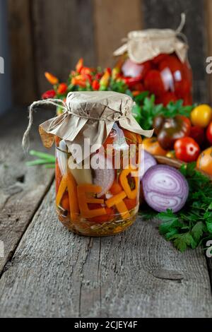 Erhaltung der Herbsternte von Gemüse. Glas mit eingelegten Tomaten. Gemüsefutter. Tomate verschiedener Sorten. Das Wort Sommer in Stockfoto