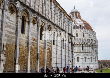 Pisa, Italien - 9. Juli 2017: Blick auf die Kathedrale von Pisa, das Baptisterium San Giovanni und Touristen auf der Piazza dei Miracoli Stockfoto