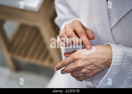 Junge kaukasische Dame, die sich um ihre Hände kümmert Stockfoto