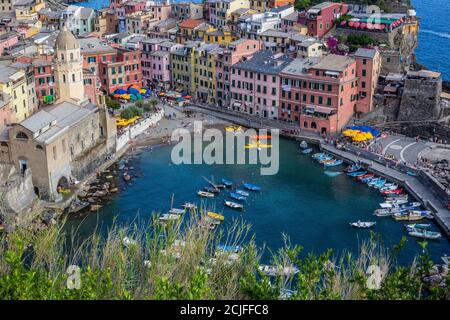 Vernazza, Italien - 8. Juli 2017: Blick auf die traditionellen alten Häuser, die Kirche Santa Margherita di Antiochia und den Strand von Vernazza Stockfoto