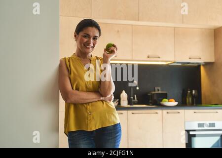 Schöne lächelnde Dame Naschen auf einem Apfel Stockfoto