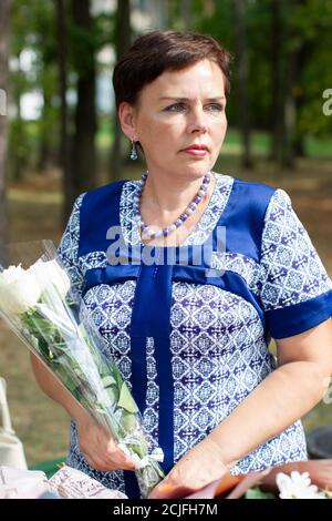 Eine Frau mittleren Alters mit einem Blumenstrauß im Park. Stockfoto