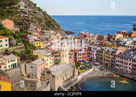 Vernazza, Italien - 8. Juli 2017: Blick auf die Kirche Santa Margherita di Antiochia und bunte Häuser mit ligurischem Meer im Hintergrund Stockfoto