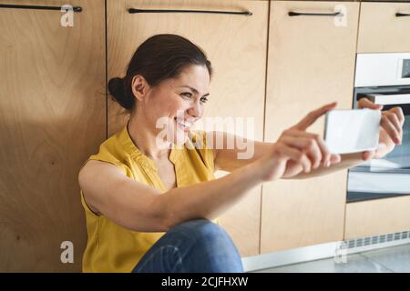 Fröhliche attraktive junge kaukasische Frau nimmt Selfies Stockfoto