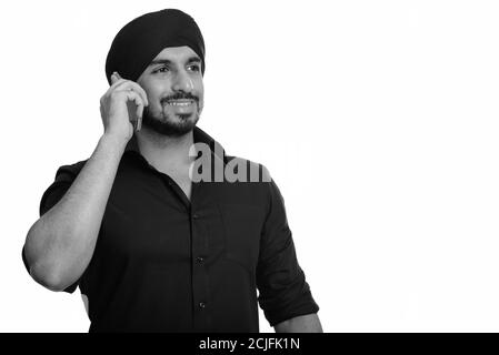 Junger glücklicher indischer Sikh Mann im Gespräch auf Handy Stockfoto