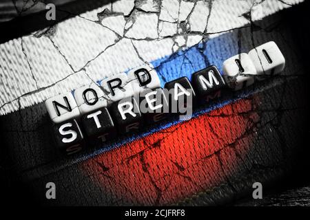 Buchstabenwürfel, die die Worte Nord Stream 2 auf der Flagge von Russland, Nord Stream 2 Gasleitung bilden Stockfoto