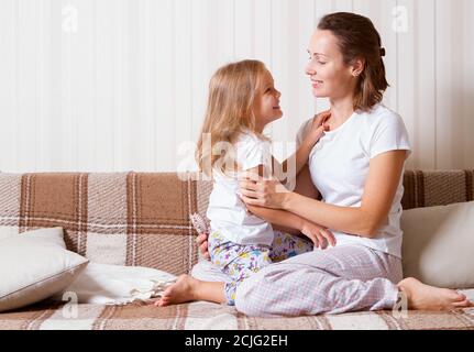 Tochter und Mutter zu Hause auf der Couch Stockfoto