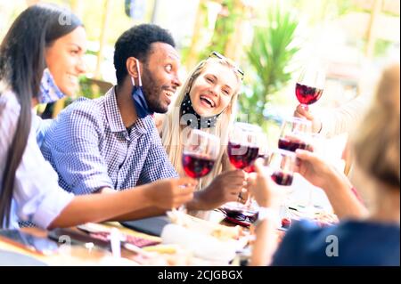 Multirassische Gruppe von Freunden genießen einen Wein in einem Restaurant - Neue normale Freundschaft Lifestyle-Konzept - Schwerpunkt auf Das blonde Mädchen Stockfoto