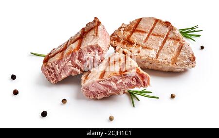 Zwei gegrillte Thunfischsteaks mit Rosmarin und Gewürzen auf Weiß isoliert. Thunfischscheiben mit Kräutern. Stockfoto