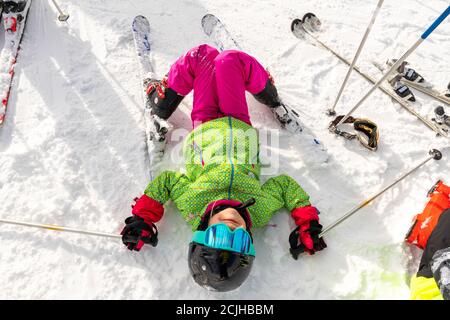 Active adorable Vorschulkinder kaukasisch lächelnd Kind Mädchen Porträt mit Ski in Helm, Brille und hellen Anzug genießen Wintersport-Aktivitäten . Wenig Stockfoto