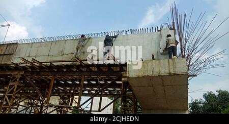 DISTRIKT KATNI, INDIEN - 17. AUGUST 2019: Indischer Dorfarbeiter, der während der Bauarbeiten auf der Straße über die Brücke macht. Stockfoto