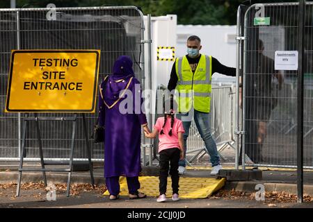 Eine Frau spricht mit einem Mitarbeiter einer Coronavirus-Testanlage in Sutton Coldfield, Birmingham. Stockfoto