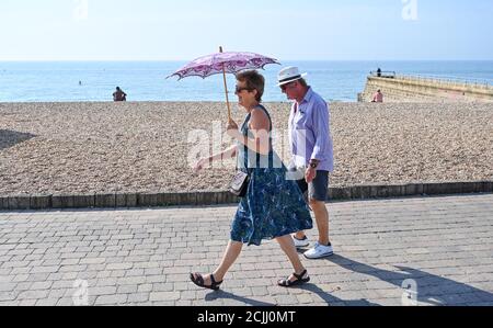 Brighton UK 15. September 2020 - Diese Dame bleibt im Schatten am Brighton Strand, da sie das Beste aus einem weiteren heißen Tag am Meer machen, da die Temperaturen in einigen Teilen des Südostens wieder 30 Grad erreichen werden: Kredit Simon Dack / Alamy Live Nachrichten Stockfoto