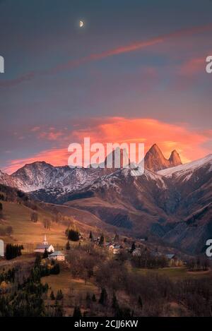 kirche in einem Dorf in den französischen alpen mit Bergen 3000 Meter hoch. Grüne Wiesen im Frühling Stockfoto