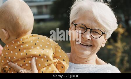 Glückliche Großmutter hält ihren Enkel Baby Junge in der Natur. Hochwertige Fotos Stockfoto
