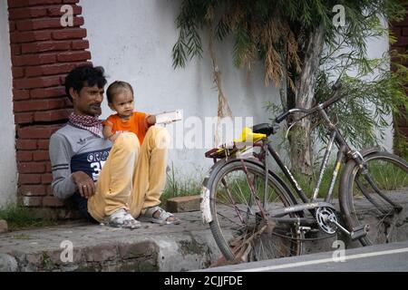 Dehradun, Uttarakhand/Indien - September 08 2020:EIN Mann mit seinem Kind, in der Nähe der Straße Stockfoto